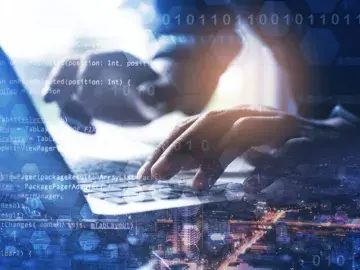 Someone typing on a laptop, superimposed with different code