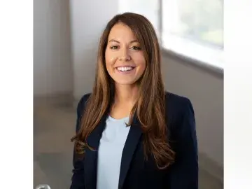 Stephanie M. Meighan n in a navy blazer near a window.