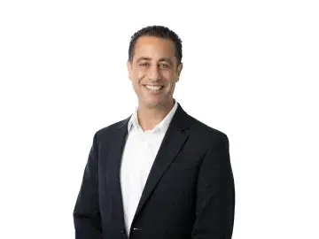 Ben Antebi in dark suit jacket and white shirt against a white background