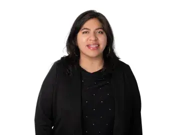 Valery Gutierrez smiling woman in black top on white background.