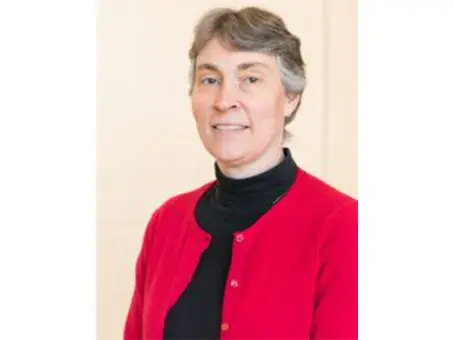 Wendy Martin with short gray hair wearing a red cardigan and black turtleneck
