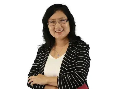 Julia Deng with glasses in striped blazer, arms crossed.
